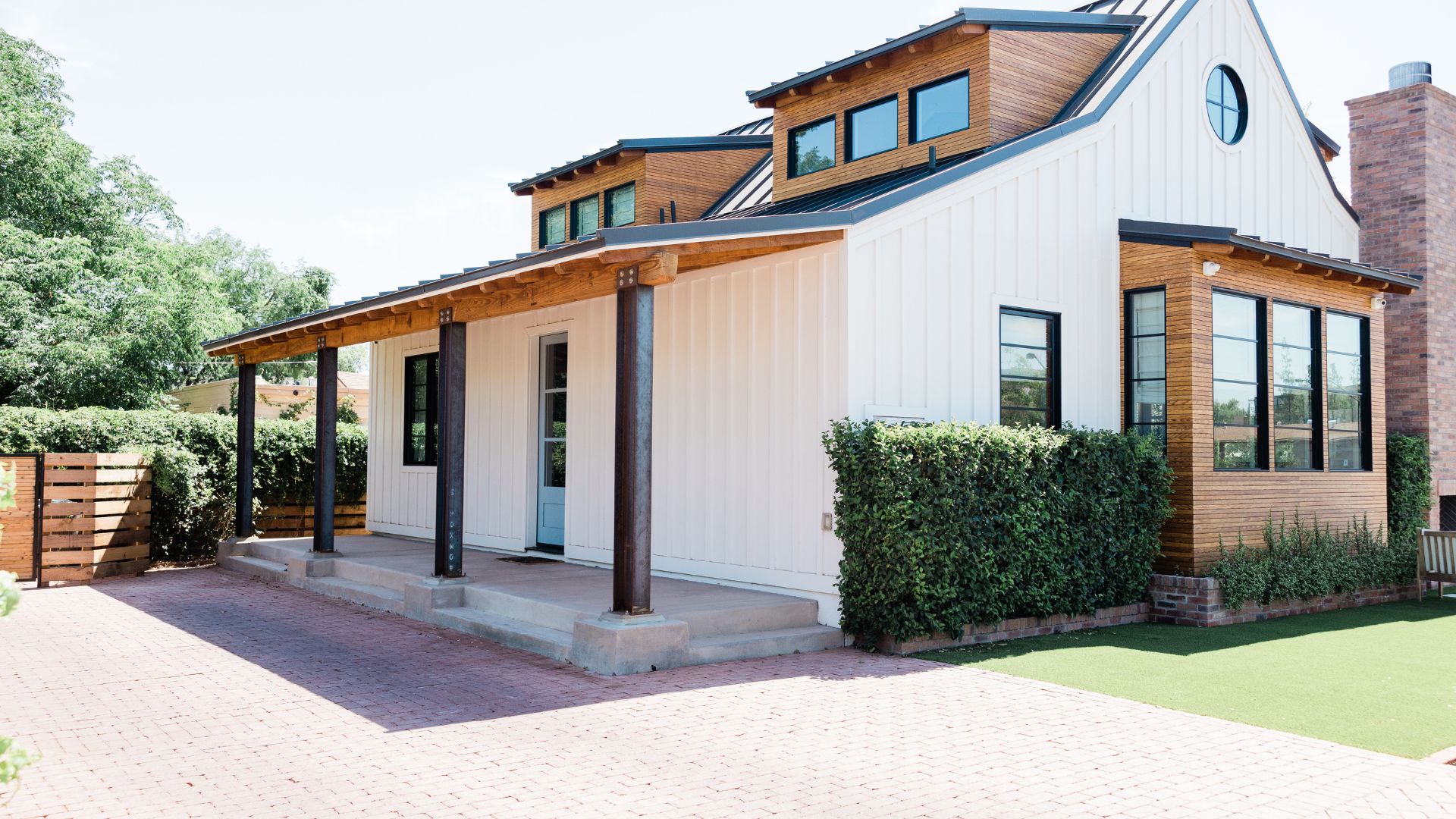 Modern farmhouse with white siding, wood accents, and covered front porch